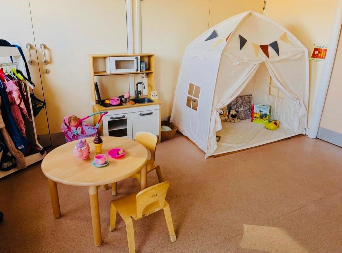 Indoor play area with a cosy reading tent and toy kitchen